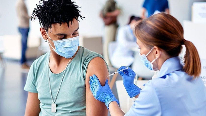 A young man receiving a vaccine in his arm