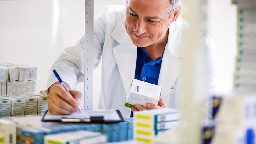 A pharmacist writes on a piece of paper